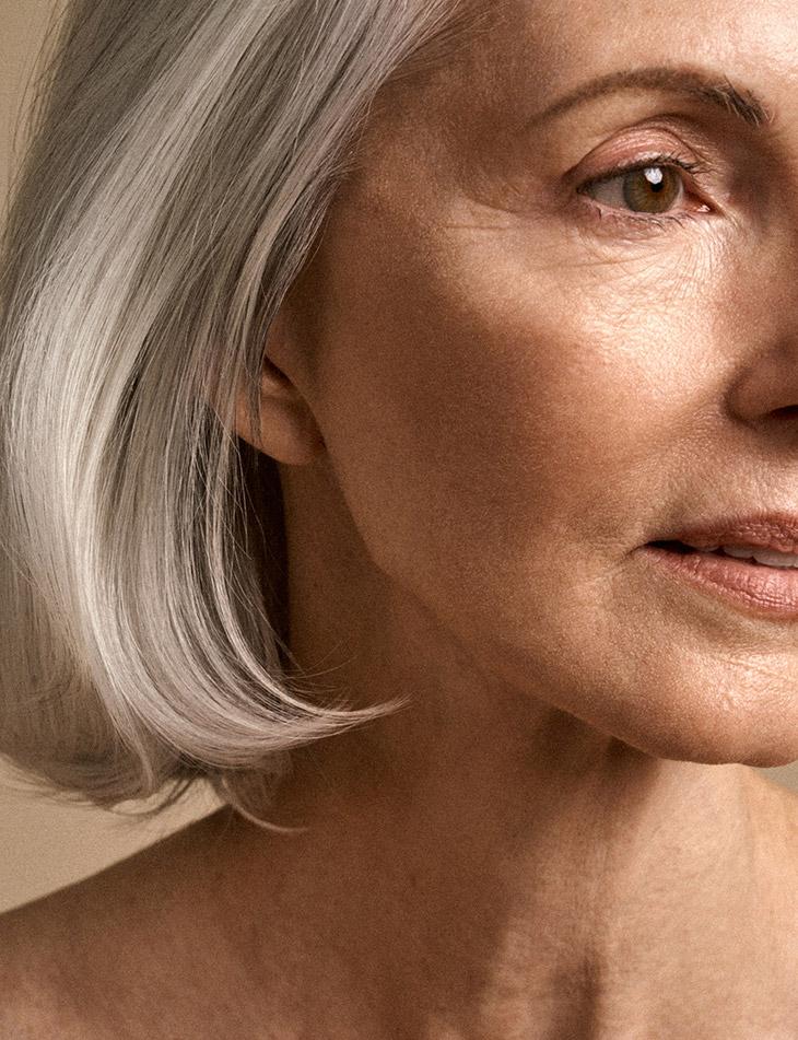 A woman with silver hair, looking upward — present, unhurried, quietly noticing.