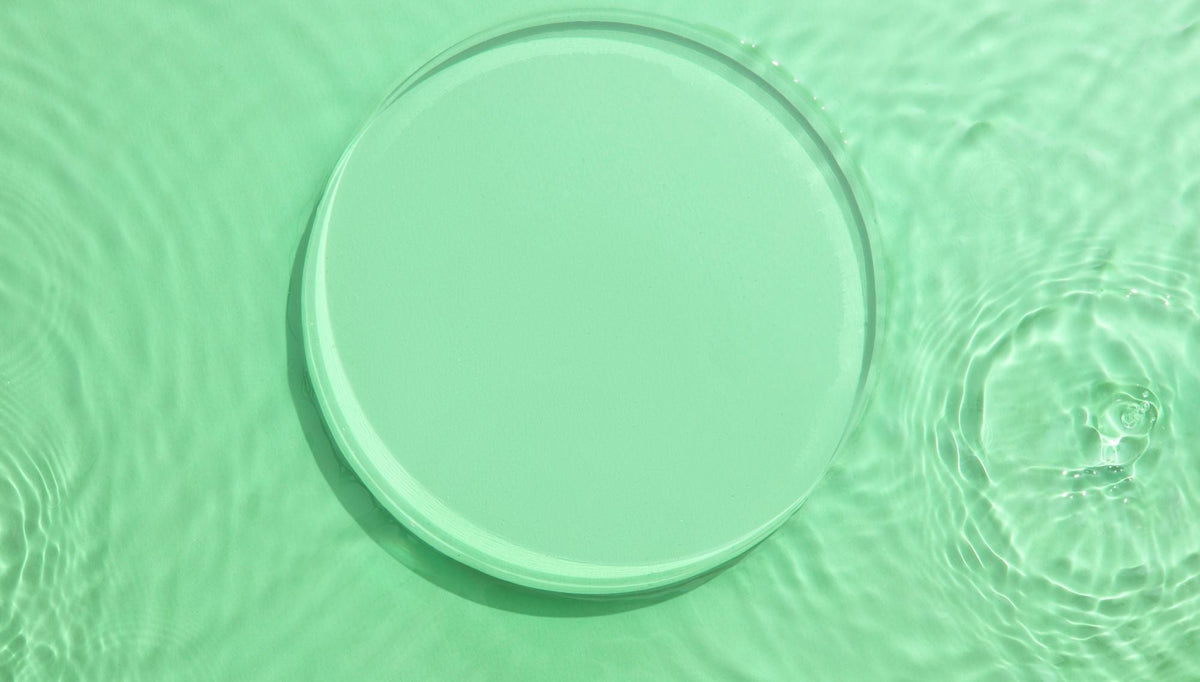 a clear water droplet on a soft green surface